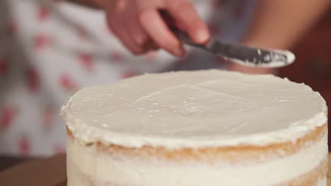 woman icing a layer cake