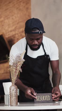 restaurant worker placing a reserved sign