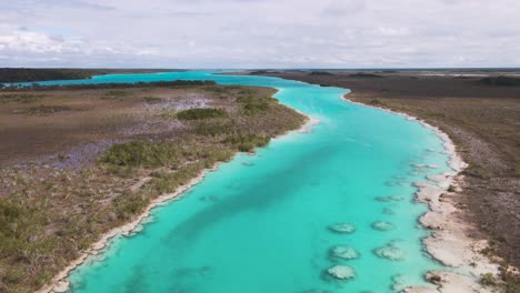 Upward-panning-drone-shot-of-the-breathtaking-"los-rapidos"-rapids-with-crystal-clear-blue-water-located-in-Bacalar,-Mexico-shot-in-4k