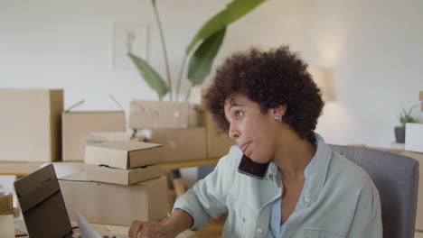 young online shop worker calling client and checking order