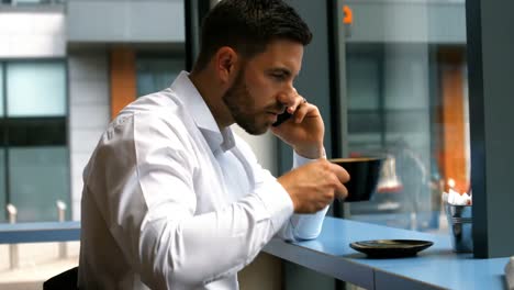 Hombre-De-Negocios-Hablando-Por-Teléfono-Móvil-Mientras-Toma-Un-Café