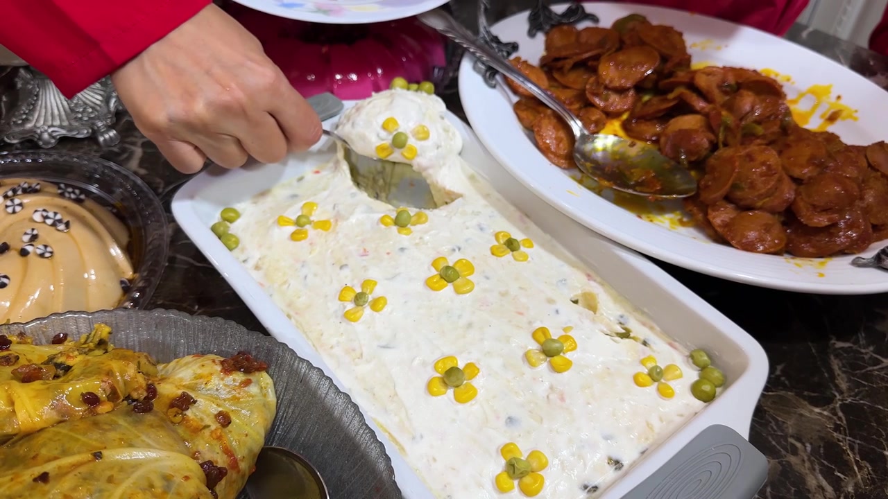 Cucina tradizionale iraniana: ciotola di insalata Olivier su tavolo da pranzo e patate cremose con piselli, maionese, uova e carne di manzo guarnita, ceramica persiana, riunione di famiglia Iran, ricetta di cibo bianco