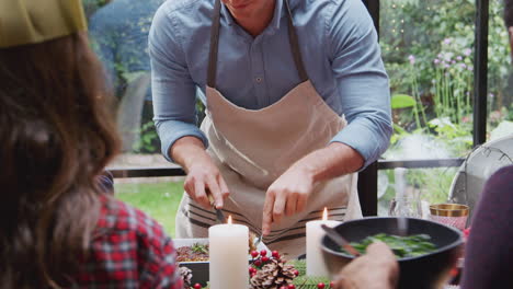 Eine-Gruppe-Von-Freunden-Sitzt-Zu-Hause-Am-Esstisch,-Während-Das-Vegetarische-Weihnachtsessen-Serviert-Wird