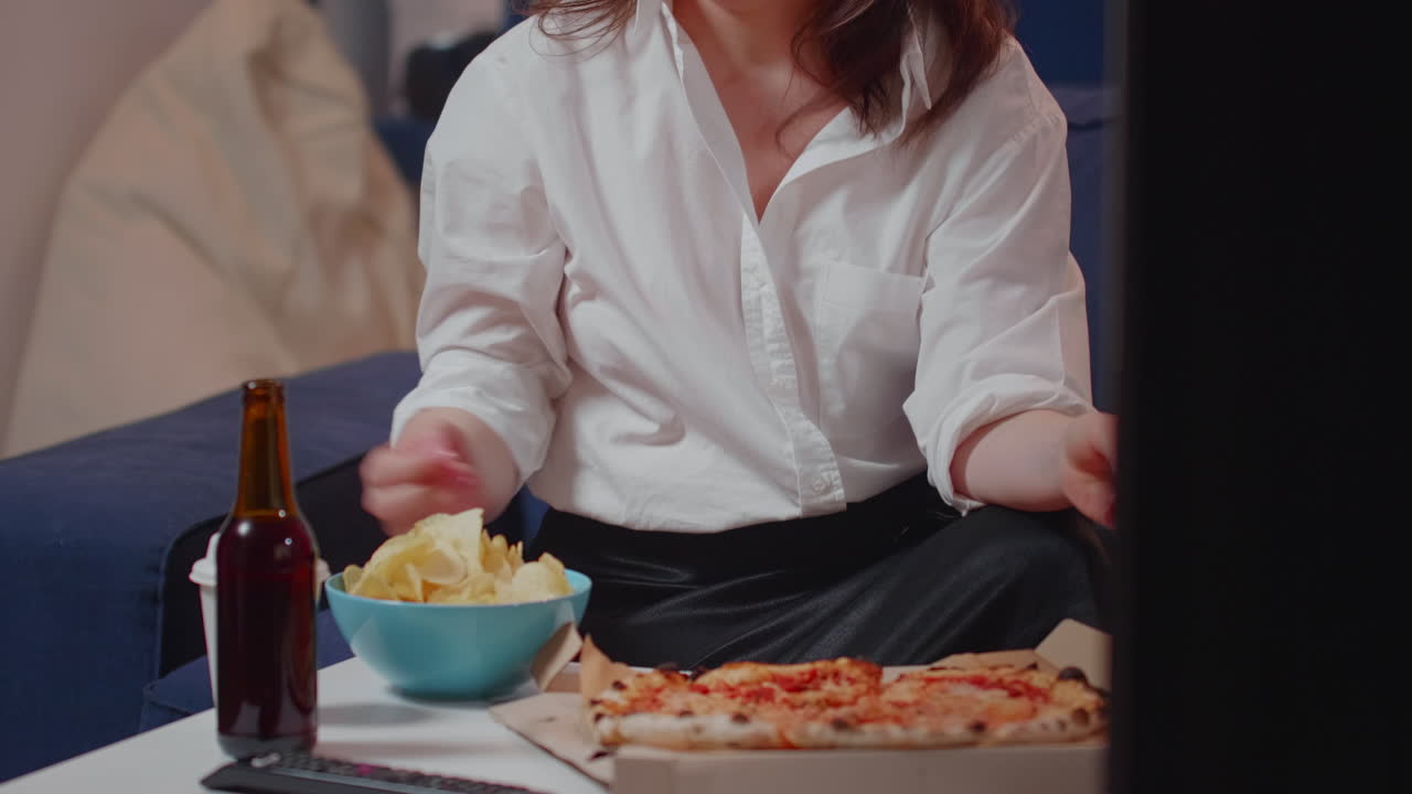 Young woman bringing pizza in living room on table