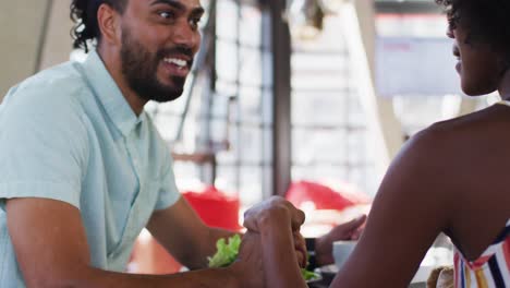 Diversos-Colegas-Masculinos-Y-Femeninos-Sentados-En-Una-Cafetería-Bebiendo-Café-Y-Discutiendo