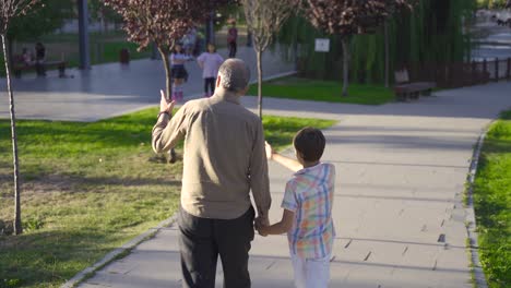 grandfather and grandchild walking outdoors.