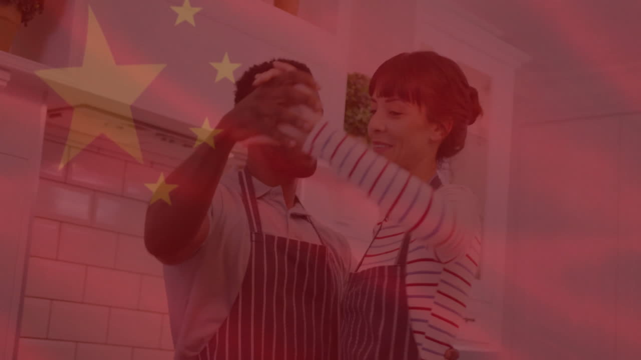 Dancing in kitchen, couple with Chinese flag animation overlay in background