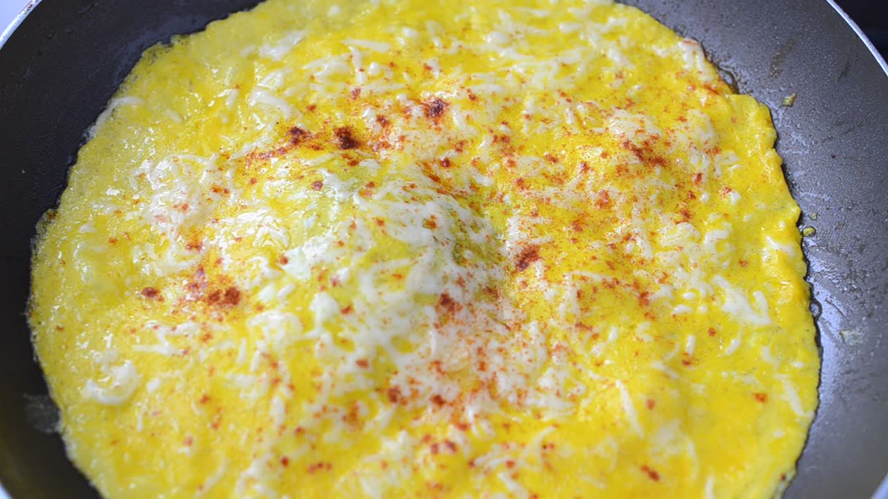 We pan fry an omelet. Omelet from eggs on a frying pan
