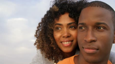 vista frontal de una pareja afroamericana abrazándose en la playa 4k