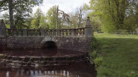 Charaktervolle,-Verzierte-Brücke-Auf-Dem-Landweg-In-Fife,-Schottland,-Mit-Einem-Kleinen-Bach,-Der-In-Einen-Teich-Mündet