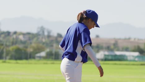 Disappointed-caucasian-female-baseball-player-holding-head-and-kicking-on-field-after-losing-a-game