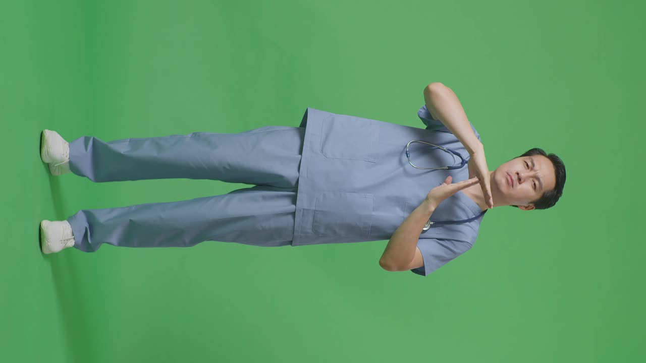 스테토스코프를 가진 아시아 남성 의사의 몸이 가득 차 있습니다. 병원에서 녹색 화면 배경에 손으로 제스처를 하고 있습니다.