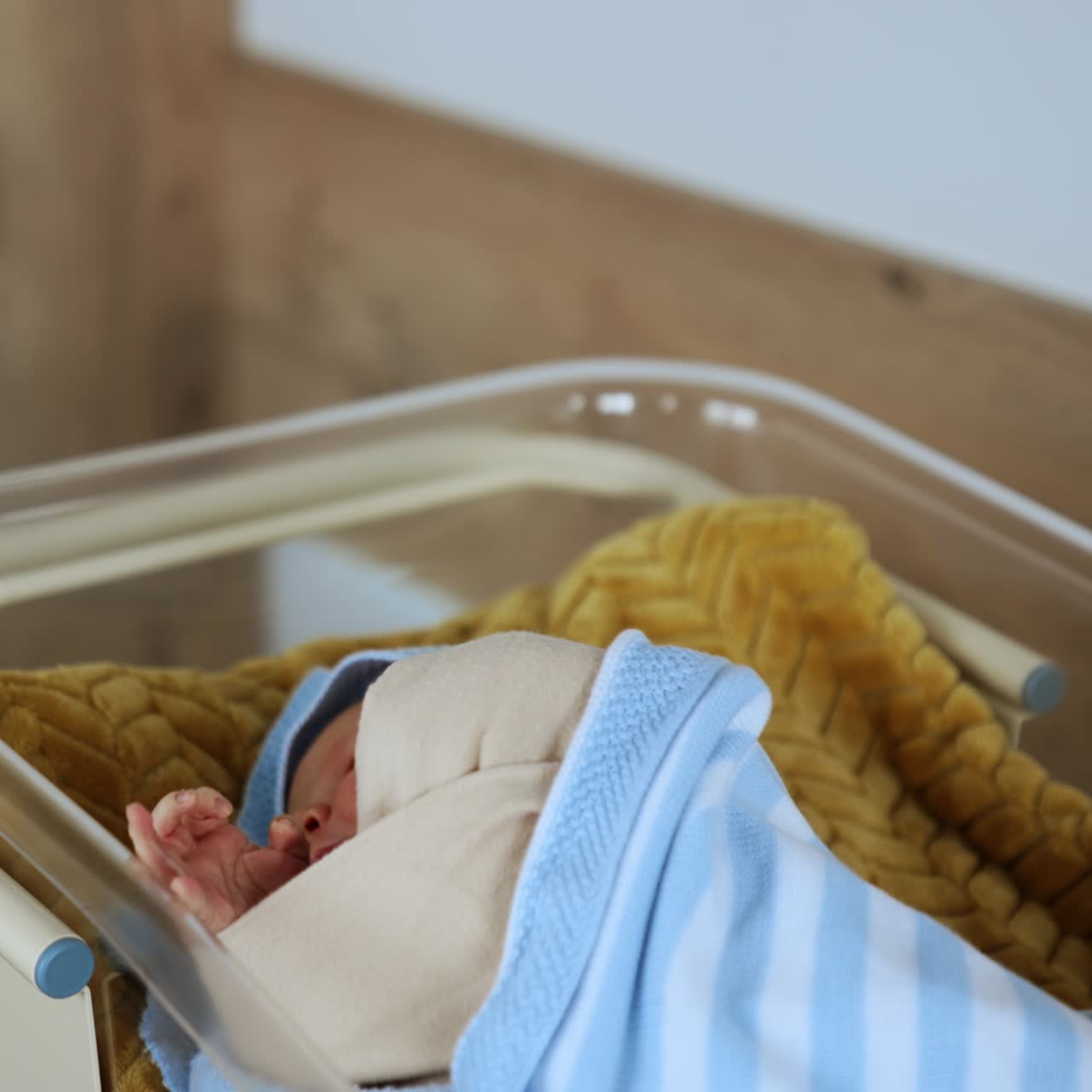Culla d'ospedale con un neonato che dorme. Un bel bambino coperto di coperte si muove nel sonno