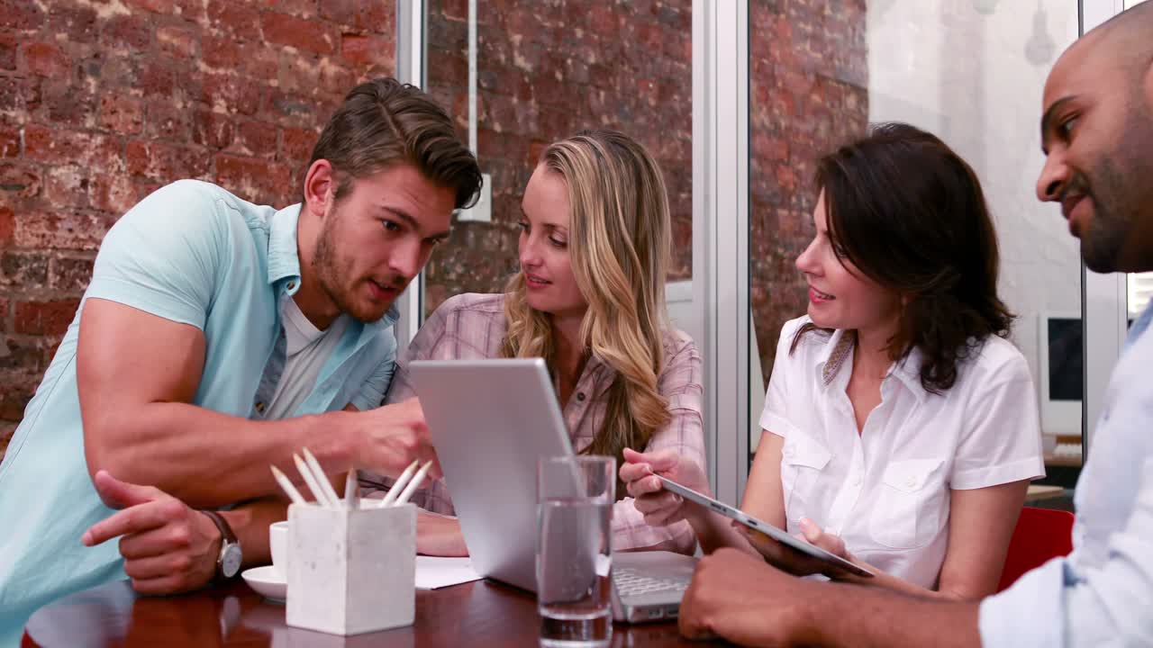 equipo de negocios casual teniendo una reunión con una computadora portátil