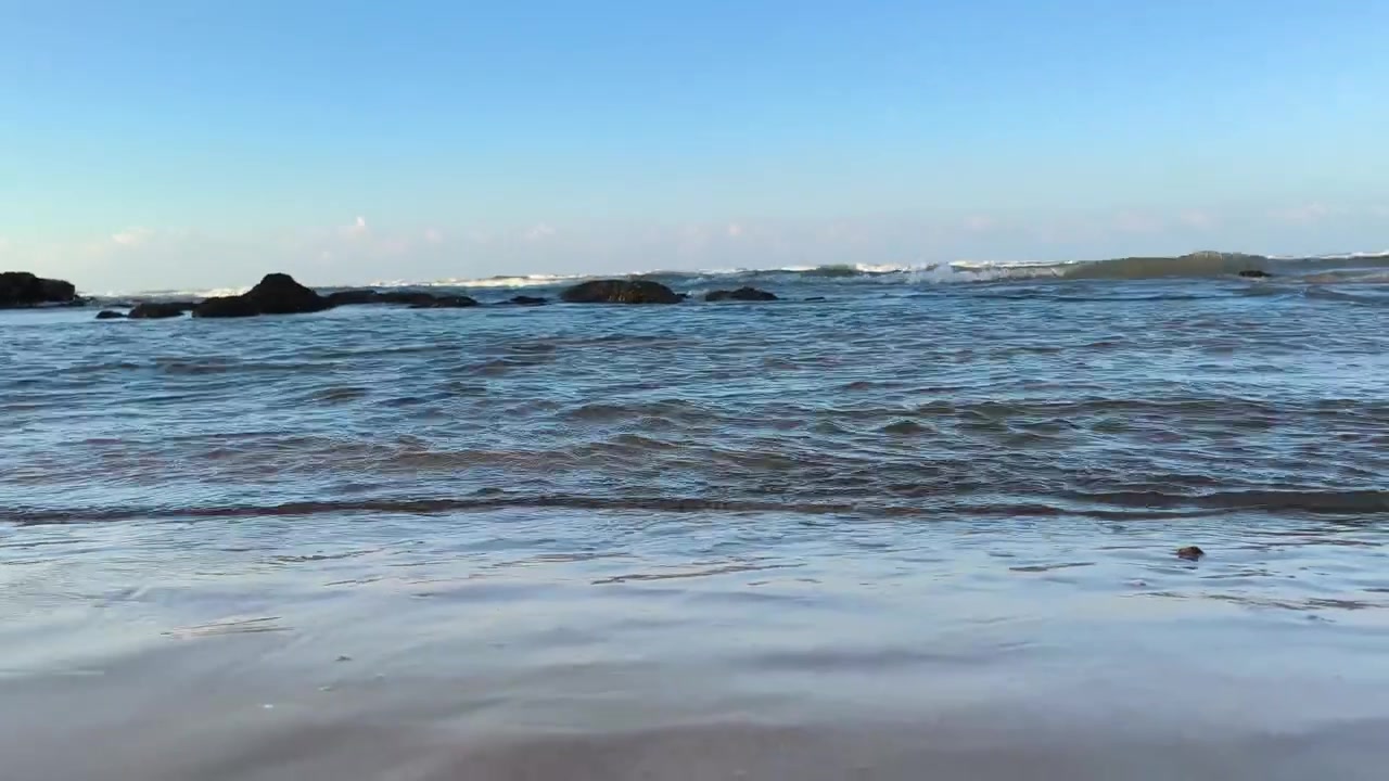 Dolci onde dell'oceano che si infrangono su una spiaggia sabbiosa.