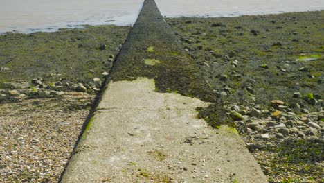 Mit-Moos-Bedeckter-Steinsteg-Am-Strand-In-Harwich,-Essex,-England