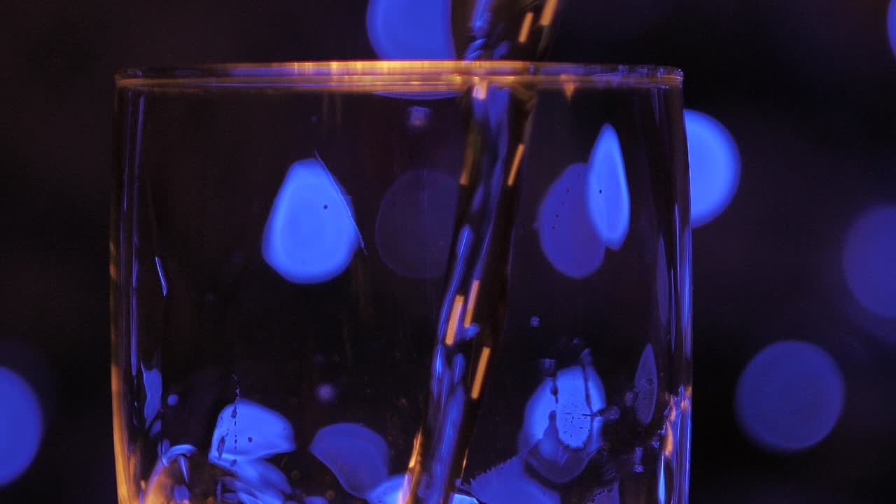 거품이 샴페인 잔에 반짝이며 천천히 회전합니다.