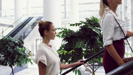 Business-people-moving-upstairs-on-a-escalator-in-office-4k