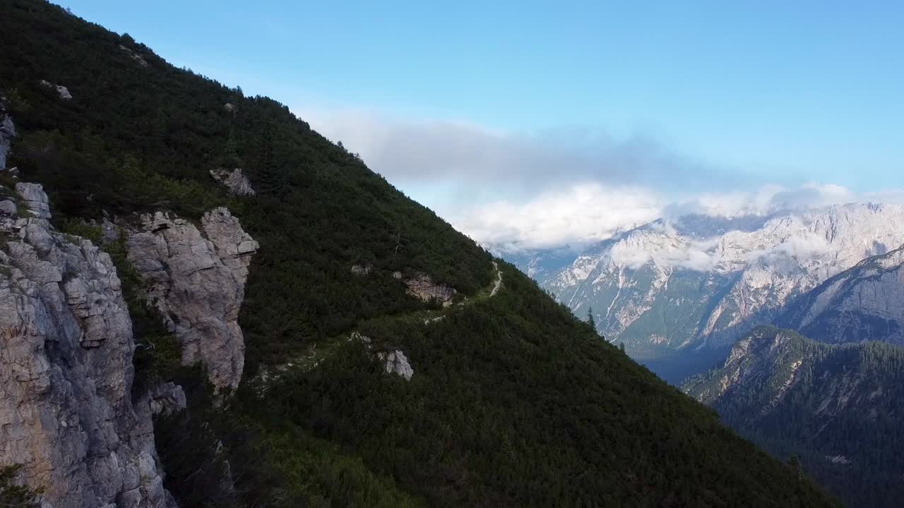 vuelo aéreo hacia adelante sobre montañas cubiertas de dolomitas en italia durante el cielo azul
