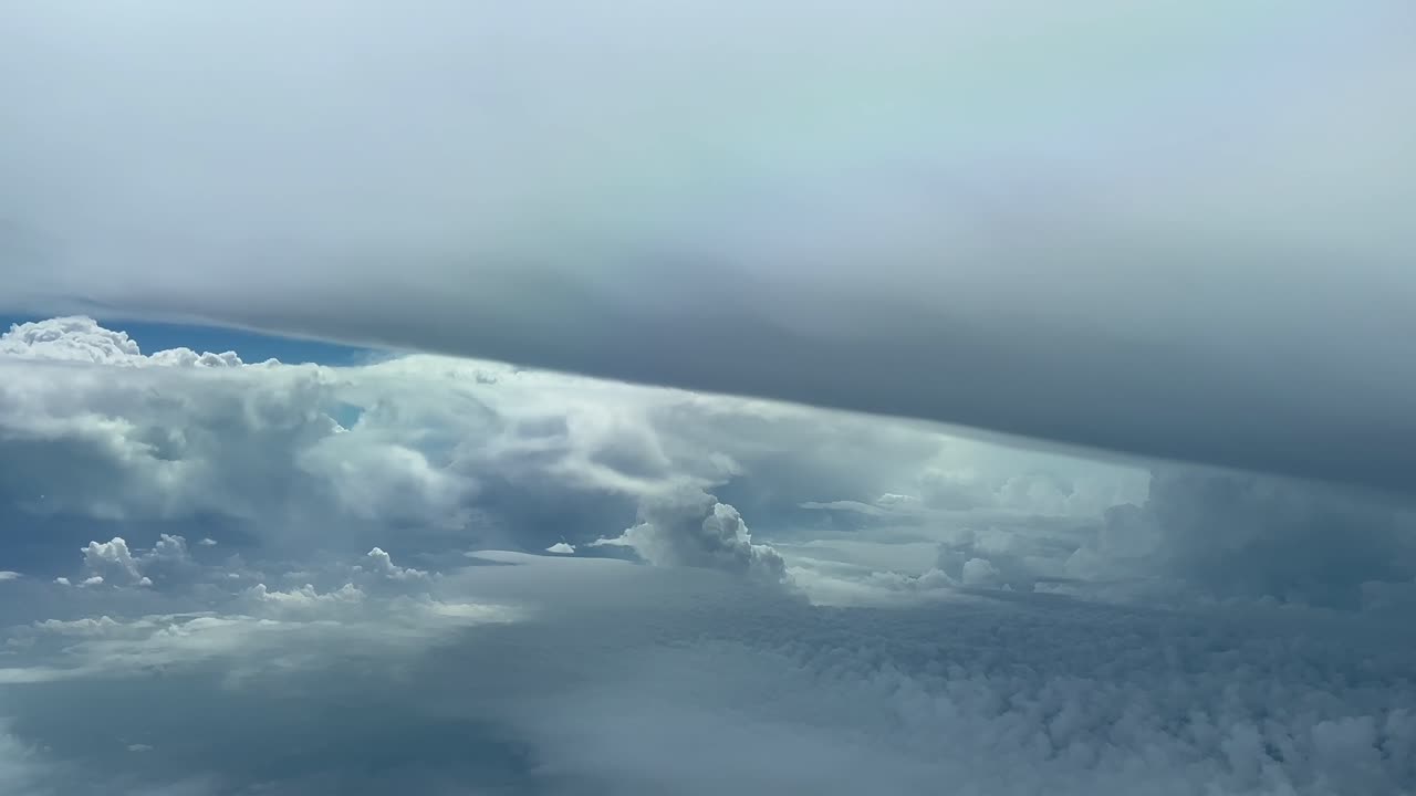 Impressive pilot POV flying near a massive cumulonimbus storm cloud in a threatening stormy sky
