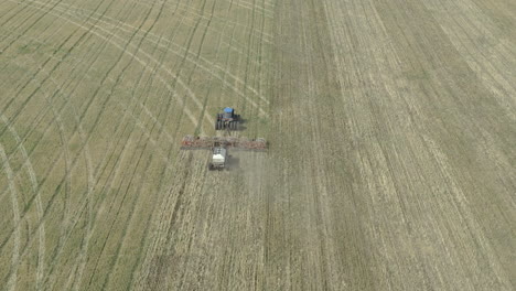 Nuevo-Cultivo-Agrícola-Que-Se-Está-Sembrando-En-Un-Vasto-Campo-Abierto,-Vista-Aérea-Inclinada-Hacia-Arriba