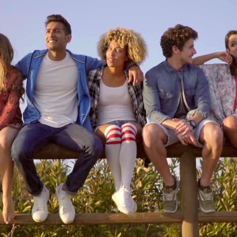 young people sitting on wooden fence