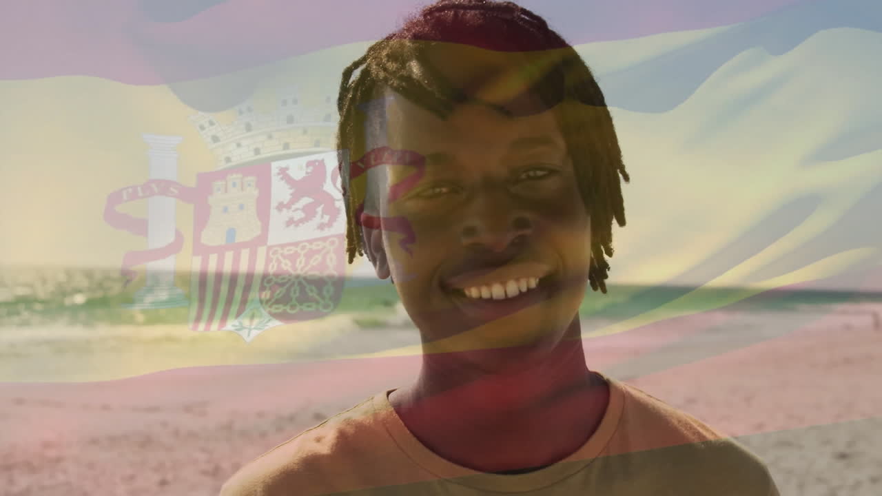 On beach, person holding Spanish flag, smiling with animation overlaying background