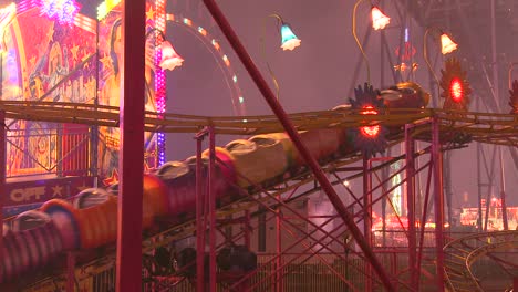 a small roller coaster at an amusement park carnival or state fair at night