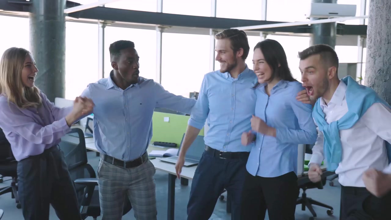 Equipe de negócios diversificada animada celebrando o sucesso em um escritório moderno