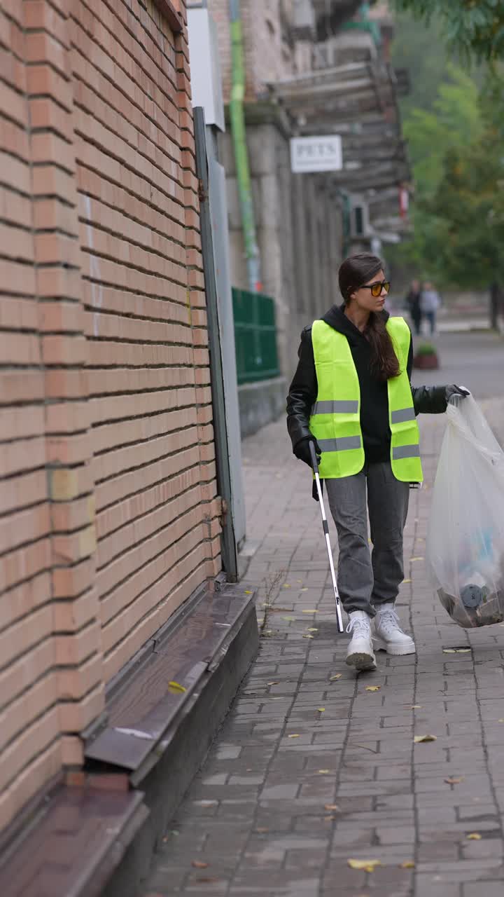 mujer limpiando la basura en una calle de la ciudad
