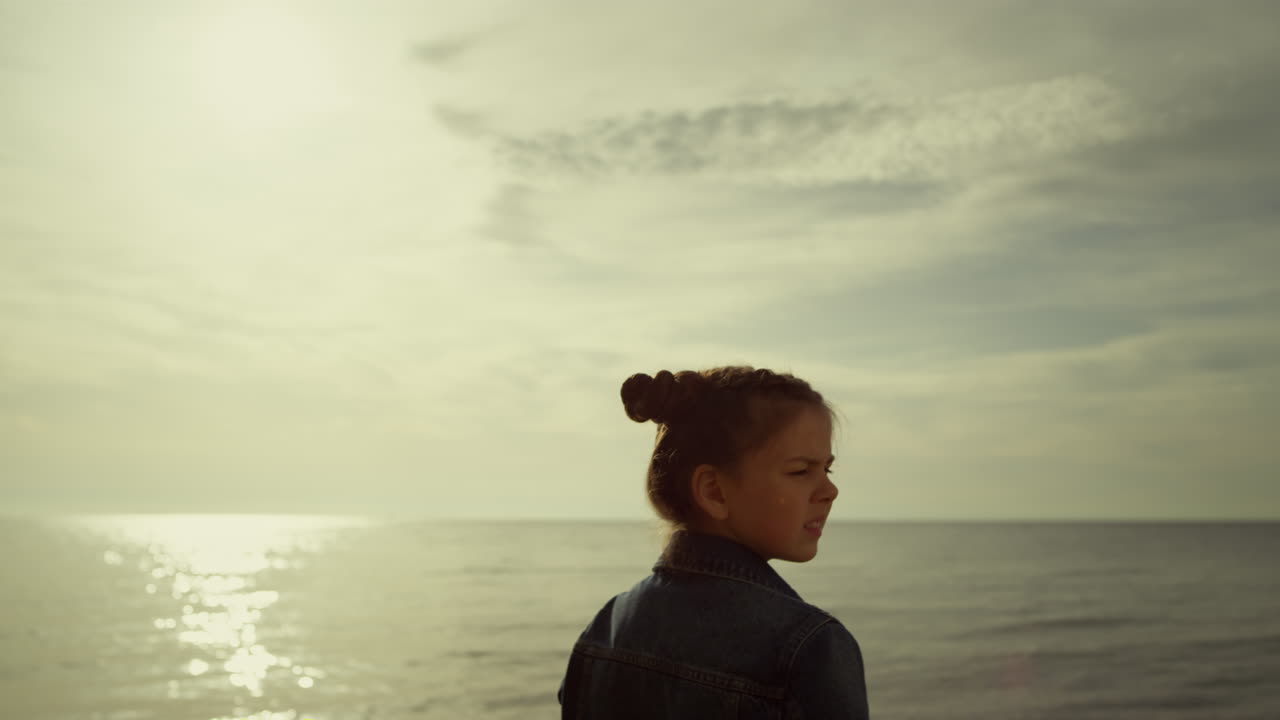 niño triste mirando la playa al aire libre. niña linda que extraña a su familia en vacaciones.