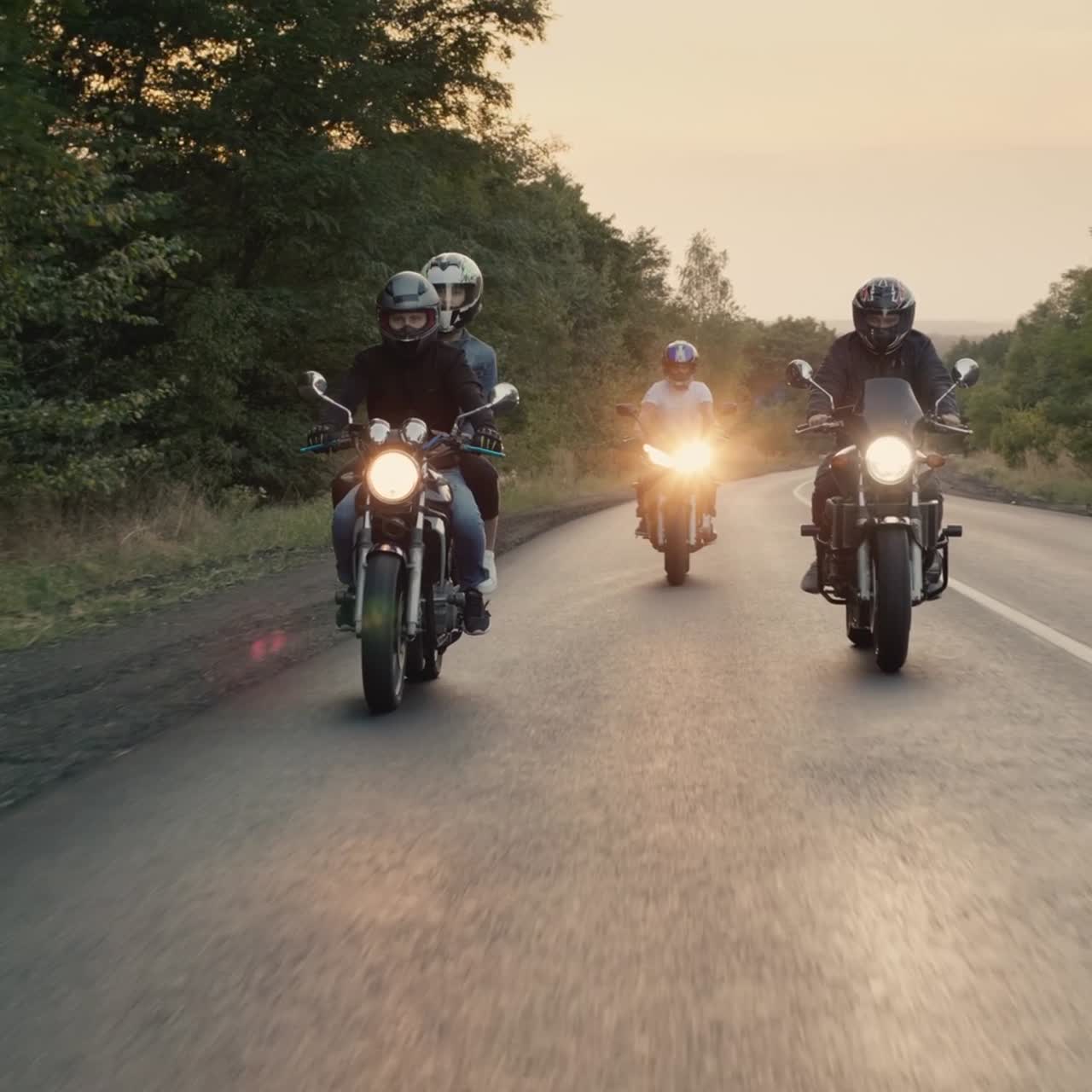 los ciclistas andan en motocicletas con las luces encendidas