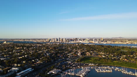 an aerial shot captures the san diego skyline in the background, with a picturesque marina in the foreground, showcasing boats docked and the vibrant cityscape.