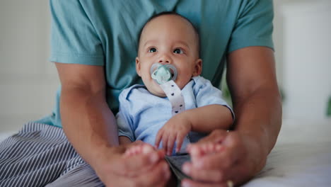 bebé, cama y padre pies se tocan