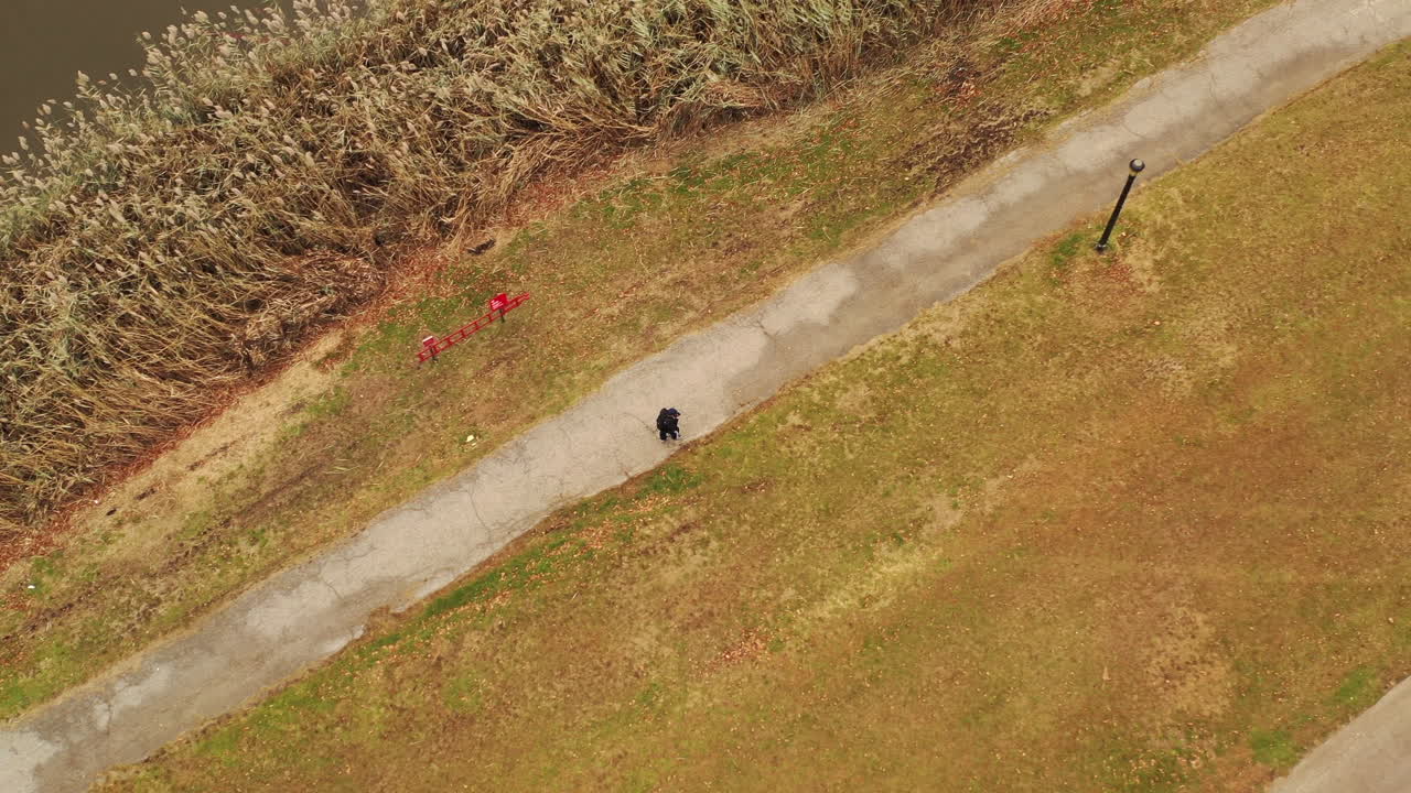 흐린 날, 플러시 메도우 코로나 공원, 퀸즈, 뉴욕, 2부에서 포장된 산책로를 따라 걷는 남자에 대한 조감도