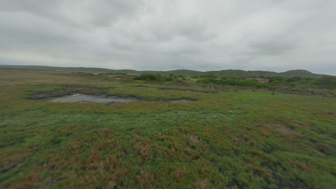 drone rápido disparado sobre un lago vidrioso hacia la desembocadura de un río