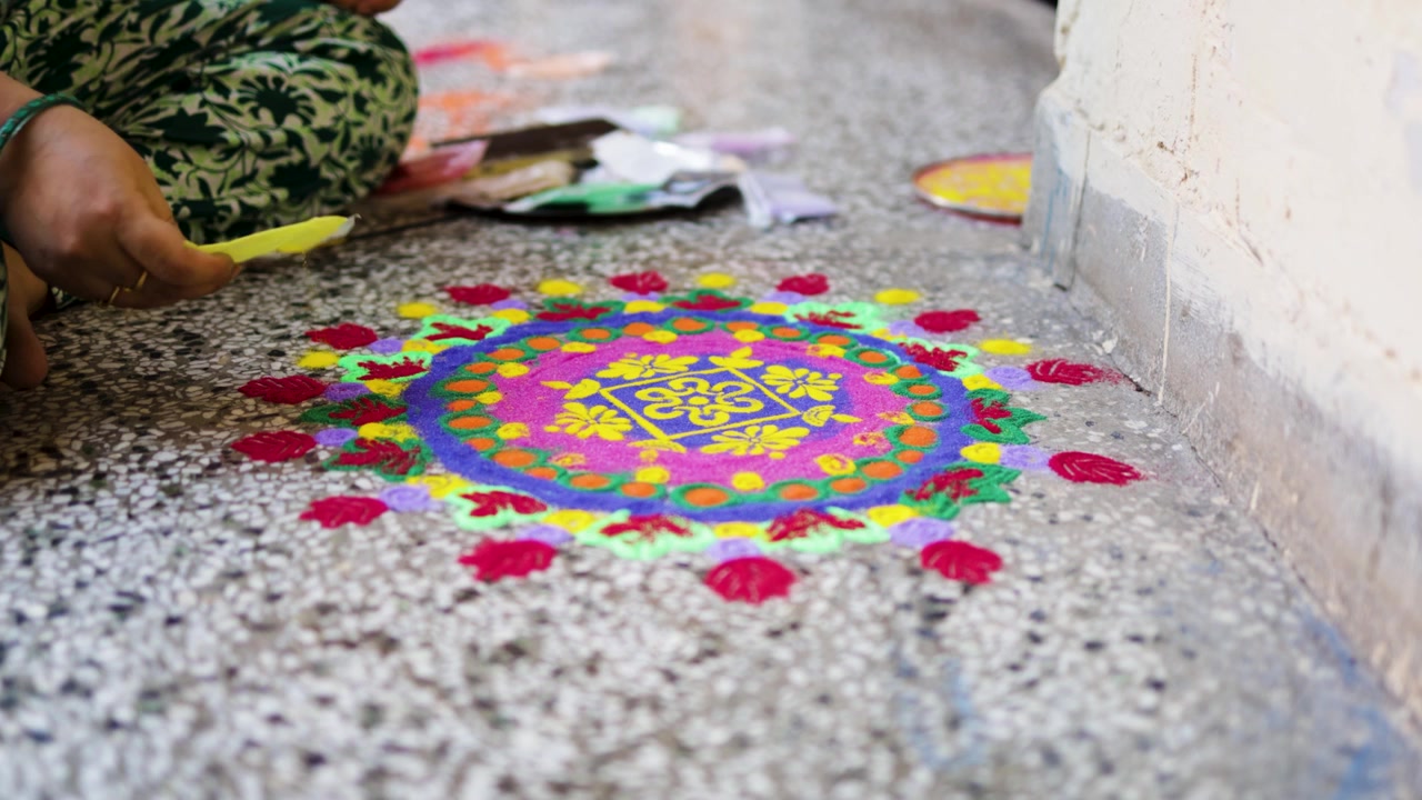 Close Up of Woman Creating Traditional Rangoli With Colored Powder on Floor