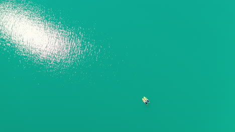 Aerial-View-Of-Two-Persons-Paddleboarding-On-Bright-Blue-Waters-Of-Lovatnet-Lake-In-Loen,-Stryn,-Norway-On-A-Sunny-Day
