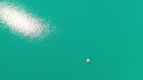 vista aérea de dos personas paddleboarding en las aguas azules brillantes del lago lovatnet en loen, stryn, noruega en un día soleado