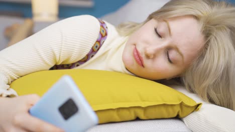 una joven rubia mirando el teléfono y regocijándose.