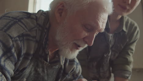 senior potter teaching young woman how to make ceramic pot