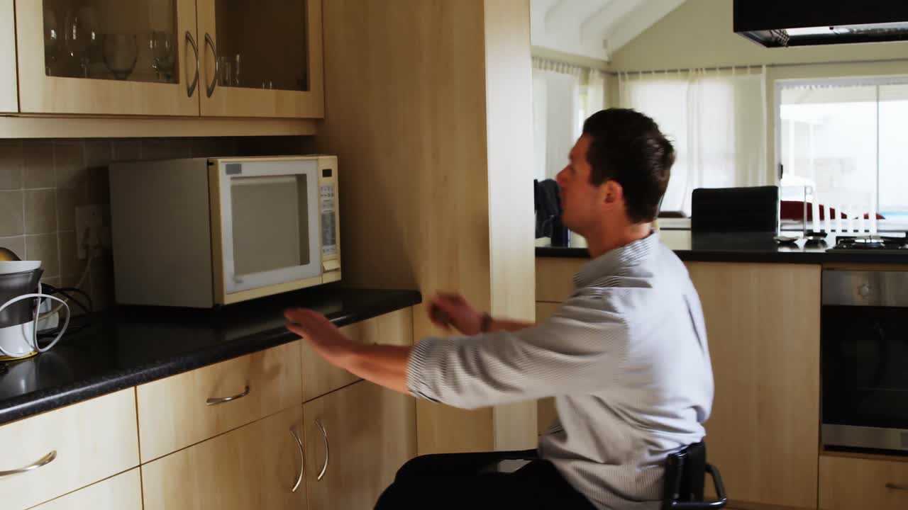hombre discapacitado usando teléfono móvil en la cocina 4k
