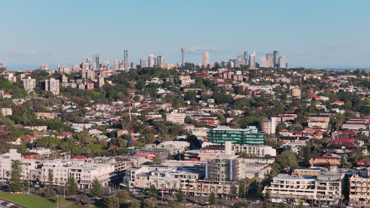 Vista aerea da teleobiettivo di gru e nuove costruzioni nel vivace mercato immobiliare di Bondi Beach, con le pittoresche colline circostanti e l'iconico skyline di Sydney, Australia, sullo sfondo
