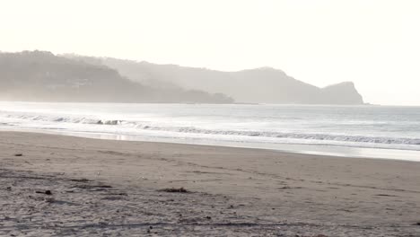 south popoyo beach nicaragua with ocean waves at dusk, handheld wide shot