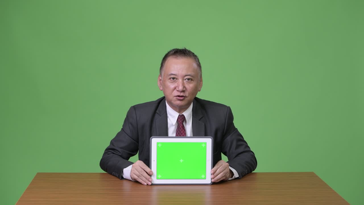 디지털 태블릿을 보여주는 성숙한 일본 사업가