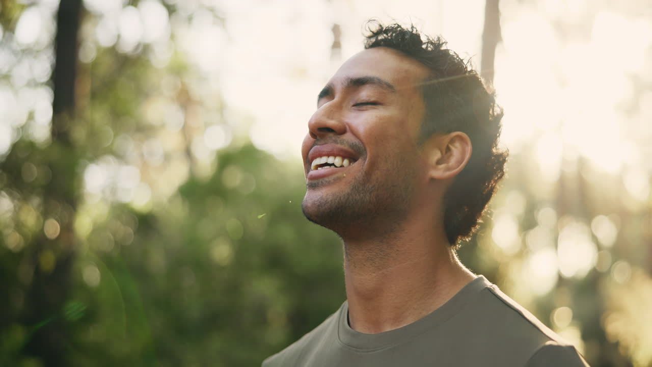 Happy Young Man Smiling with Eyes Closed in Sunny Forest