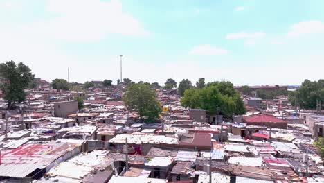 close-up aerial orbital panning shot of informal settlement in alexandra township, johannesburg, south africa, on a sunny day with scattered clouds
