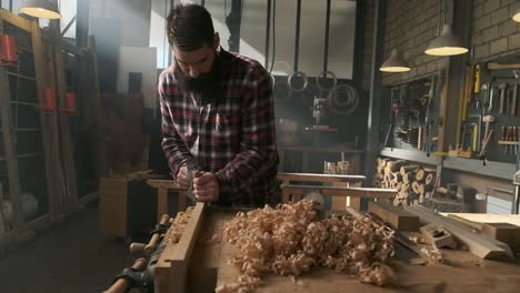 carpintero planeando madera en el taller de moody