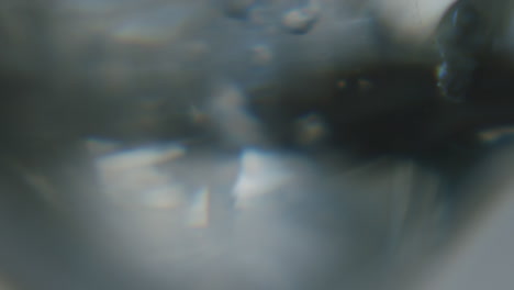 white transparent fluid with small crystals inside moving slowly