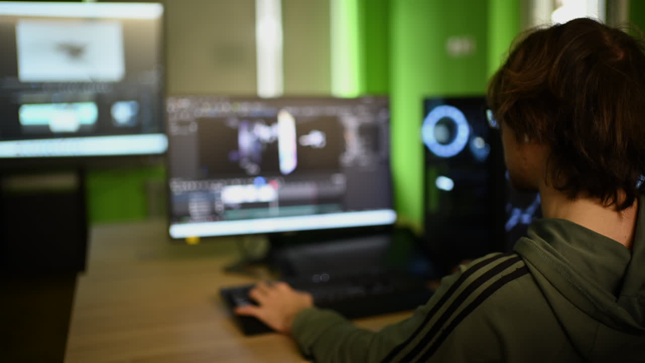 Man working on video editing software on computer in a modern workspace